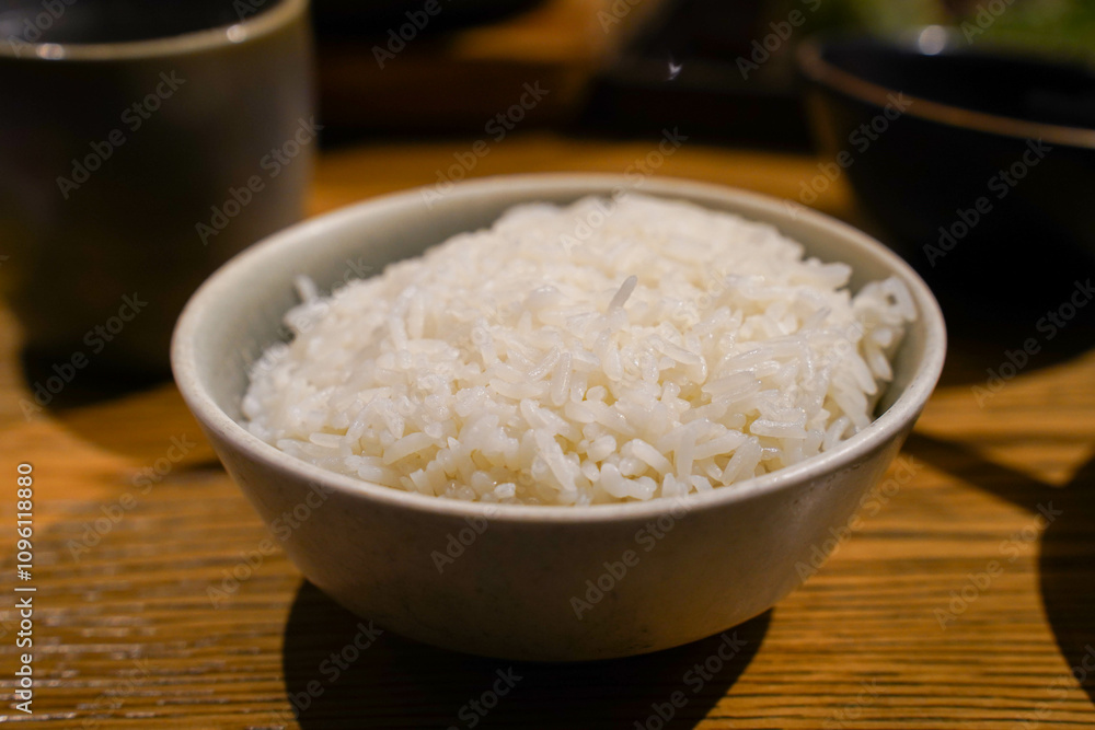 cooked rice cooked in a bowl on wooden table in restaurant.