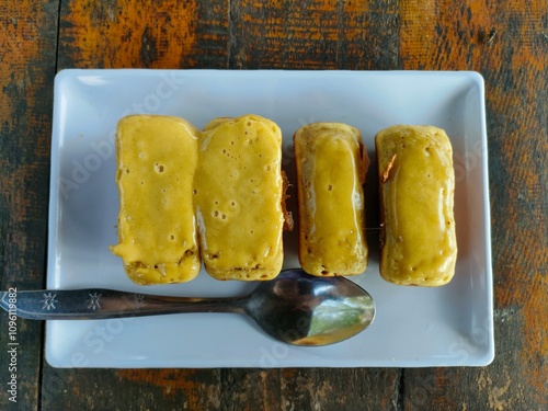 A portion of block cake on a rectangular white plate 