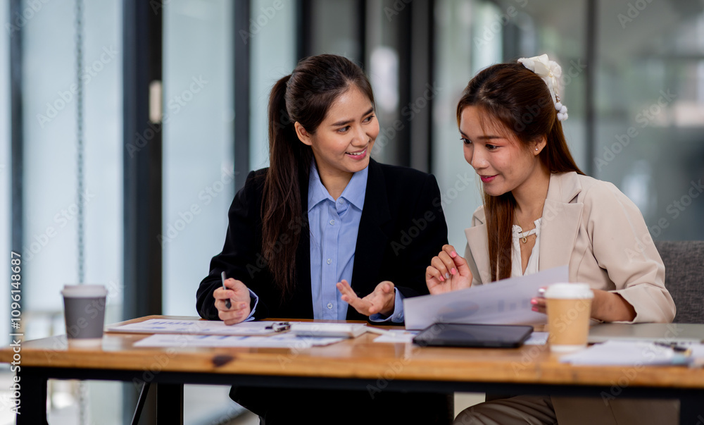 Two asian business women discuss financial management planning.standing and talking about analyzing documents in the workplace office
Two asian business women discuss financial management planning.standing and talking about analyzing documents in the workplace office
