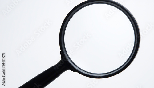 The image displays a magnifying glass with a round, clear lens and a black handle. It is positioned against a neutral background. There are no texts or additional objects visible in the image.
