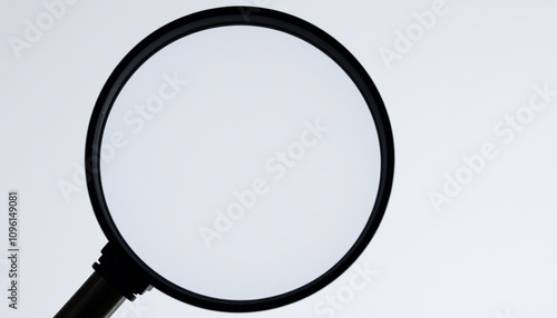 The image displays a magnifying glass with a round, clear lens and a black handle. It is positioned against a neutral background. There are no texts or additional objects visible in the image.