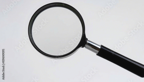 The image displays a magnifying glass with a round, clear lens and a black handle. It is positioned against a neutral background. There are no texts or additional objects visible in the image.