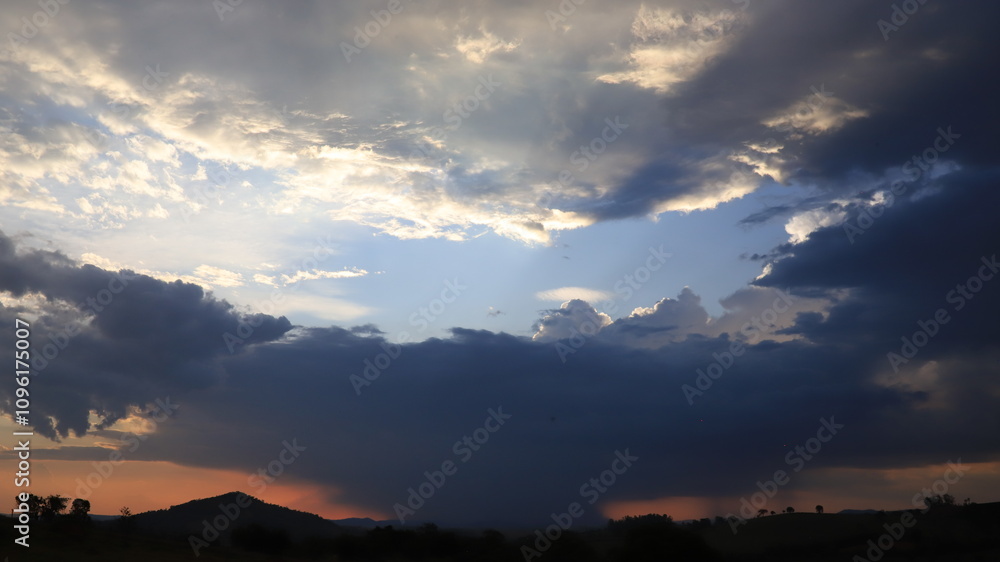 Fototapeta premium Contrast of White and Black Clouds in the Sky, Capturing the Dramatic Beauty of Nature with Bold Shadows and Light, Perfect for Representing Stormy Weather, Atmospheric Drama, or a Moody Sky