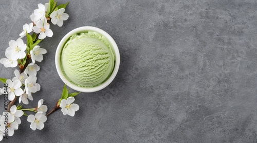 Green ice cream in a bowl with cherry blossoms.