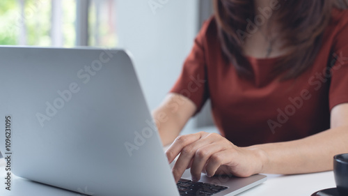 Woman working on laptop computer at home office. Business woman typing on notebook computer, surfing the net, searching the information, online working at home, closeup