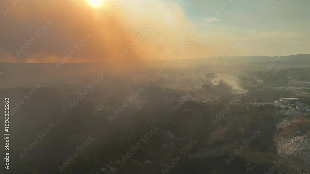 Aerial view of dangerous fire in the forest close to highway and village. Flying above forest fire at the sunset time. Drone flight over burning bushes and forest close to the road. Aerial view of dangerous fire in the forest close to highway and village. Flying above forest fire at the sunset time. Drone flight over burning bushes and forest close to the road.