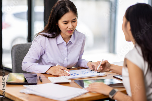 Financial Business two women analyze the graph of the company's performance to create profits and growth, Market research reports and income statistics, Financial and Accounting concept.	