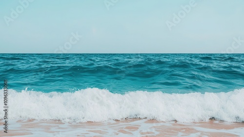 Tranquil Ocean Waves Gently Crashing On Sandy Shore Under Clear Blue Sky, Ideal For Calm Summer Vibes and Coastal Serenity Themes In Stock Photography