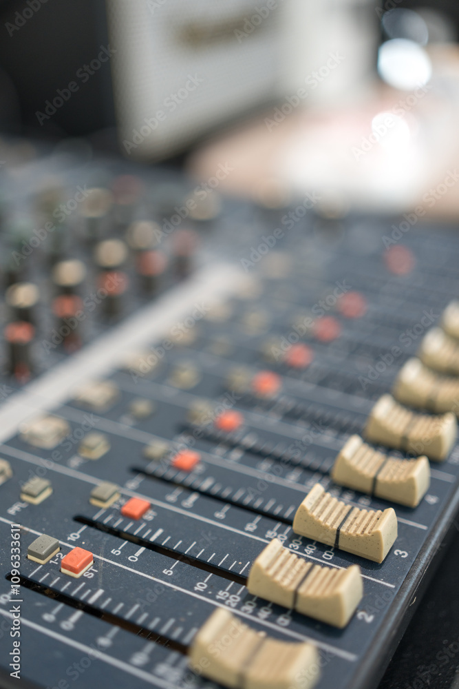 Amplifying equipment adjusts studio audio mixer knobs and faders. Selective focus Amplifying equipment adjusts studio audio mixer knobs and faders. Selective focus