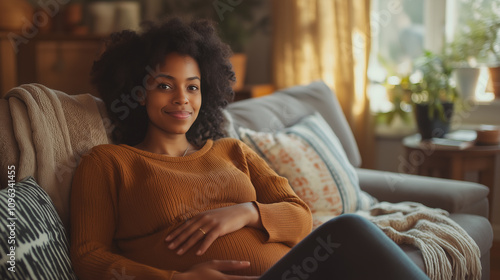 Pregnant woman relaxing at home on a cozy sofa, touching her belly with a calm and happy expression. Warm natural light and soft textures create a serene, comfortable atmosphere 