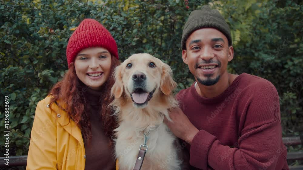 Joyous multiethnic couple sits with golden retriever on bench Joyous multiethnic couple sits with golden retriever on bench