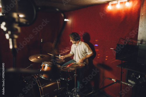 Photography Drummer experimenting with new sounds in a music studio