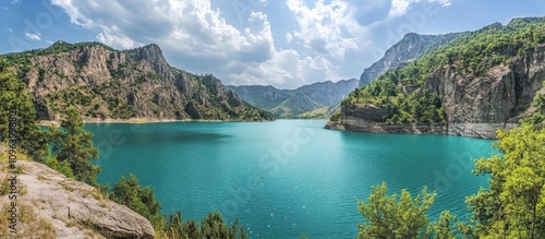 Civril Isikli Lake panoramic view surrounded by lush hills and mountains under a bright blue sky with fluffy clouds. photo