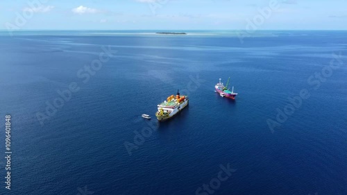 Aerial drone view of a large ship on a calm ocean during a sunny day.
