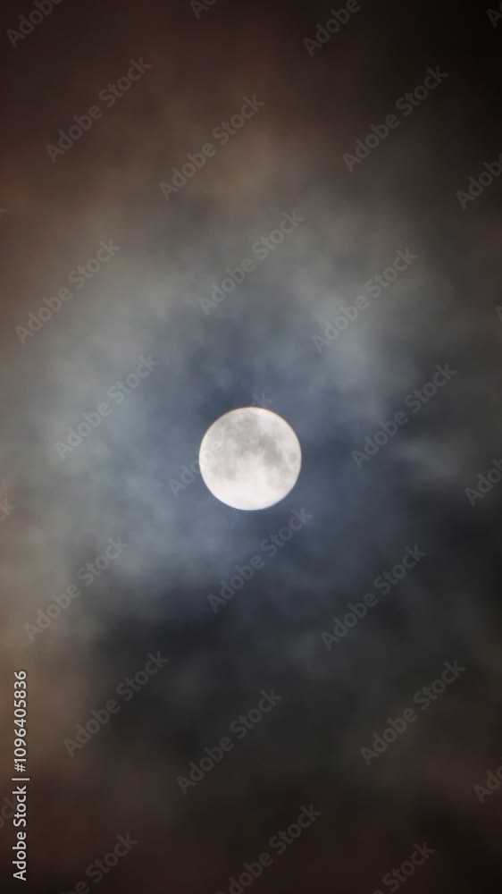 A magical full moon in the night sky with clouds. The full moon is a time of mysticism, horror, magic and witchcraft. Vertical video, shorts. A magical full moon in the night sky with clouds. The full moon is a time of mysticism, horror, magic and witchcraft. Vertical video, shorts.
