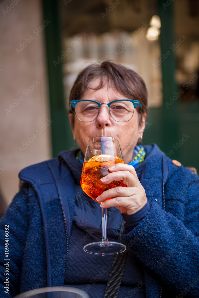 Fototapeta premium A woman drinks a cocktail in a café in Verona,Italy
