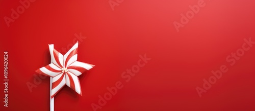 Festive red background with a white straw star and striped candy cane ideal for postcard design or holiday greeting text placement.