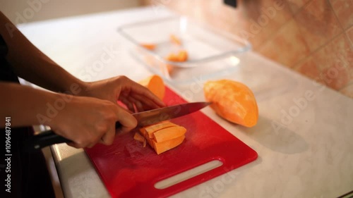 Housewife cuts raw sweet potato into strips on a cutting board on the table. High quality 4k footage