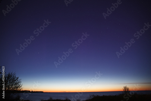 Obraz na płótnie Night clear sky view with starts and late sunset on horizon, sea shore w salonie