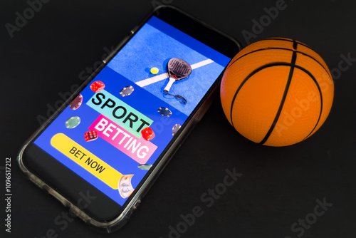 smartphone with application for sport bets and a basketball ball, concept of online bets  photo