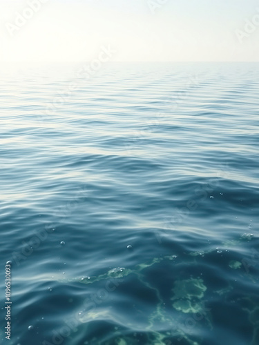 Calm ocean waters with ripples on the surface, sunlight, waves