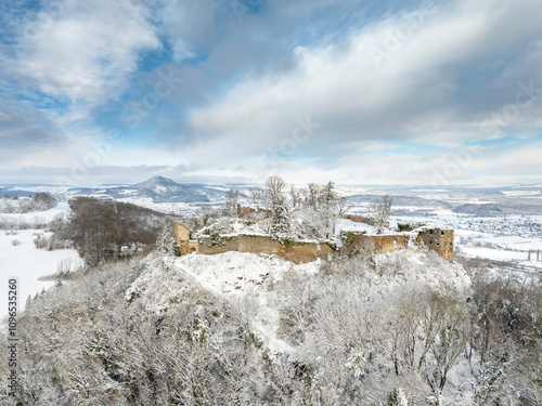 Luftbild vom verschneiten Hegauvulkan Mägdeberg mit Mauerresten einer Burg an einem kalten Wintermorgen