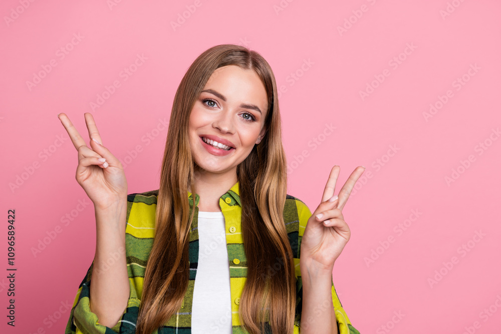 Photo portrait of lovely young lady show v-sign dressed yellow plaid clothes isolated on pink color background Photo portrait of lovely young lady show v-sign dressed yellow plaid clothes isolated on pink color background