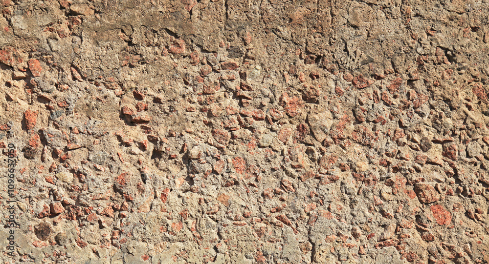 Rough wall. Concrete with a visible base of granite stones. An old crumbled and cracked surface, background. Detailed texture and backdrop of concrete close-up. Beaten and chipped cement foundation Rough wall. Concrete with a visible base of granite stones. An old crumbled and cracked surface, background. Detailed texture and backdrop of concrete close-up. Beaten and chipped cement foundation
