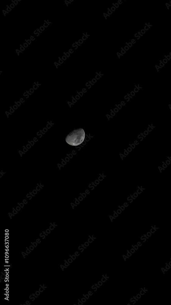Vertical view of the moon against dark night sky Vertical view of the moon against dark night sky