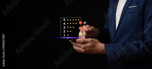 Obraz na płótnie Businessman using a smartphone to provide feedback with a 5-star scale and emoji options, representing customer evaluation and digital interaction. w salonie