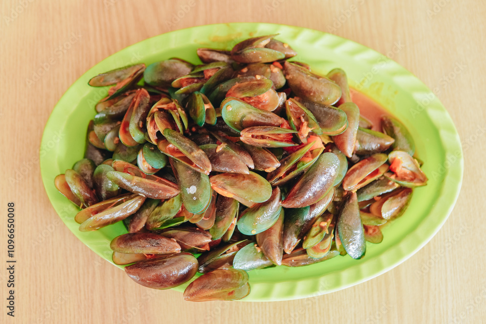 A seafood dish made from clams with sweet and sour sauce, menu in a seafood restaurant. A seafood dish made from clams with sweet and sour sauce, menu in a seafood restaurant.