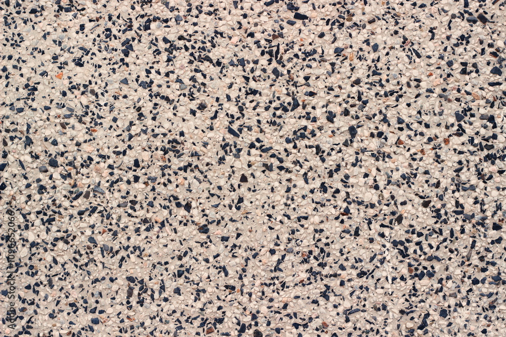 The texture of a mosaic surface with black and white stones evenly distributed on a light base The texture of a mosaic surface with black and white stones evenly distributed on a light base