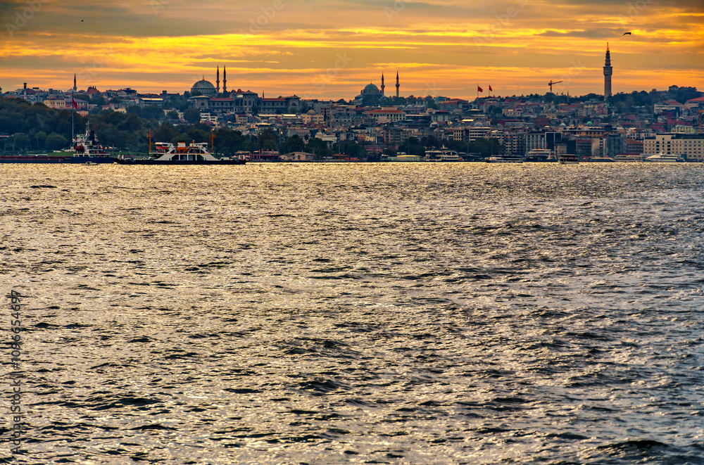 Fototapeta premium view from a pleasure boat on the Bosphorus and the cityscape of Istanbul, Turkey, the architecture of the city at sunset, a popular tourist destination.