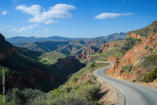 A winding road through a scenic mountainous landscape under a clear blue sky.