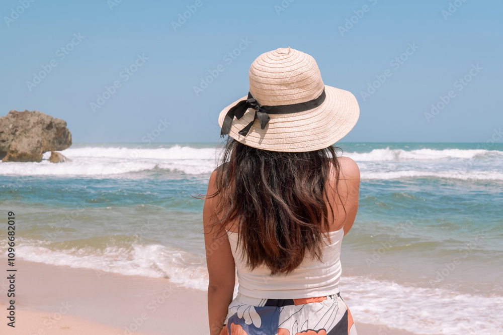 Back portrait of a young Indonesian woman enjoying the view of Drini beach in Yogyakarta. Back portrait of a young Indonesian woman enjoying the view of Drini beach in Yogyakarta.