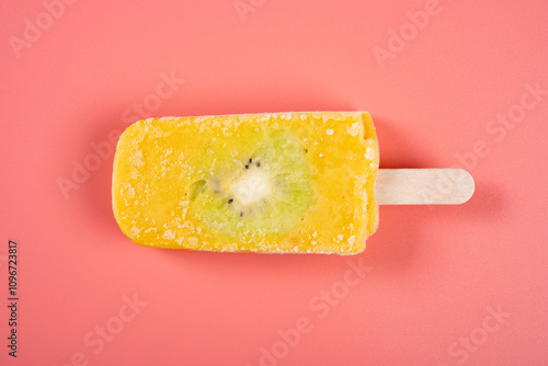 fresh mango and milk flavor popsicle with slice of kiwi fruit on pink background photo