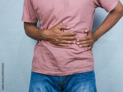 Konstfotografi Young man suffering from an abdominal pain, healthcare concept white background