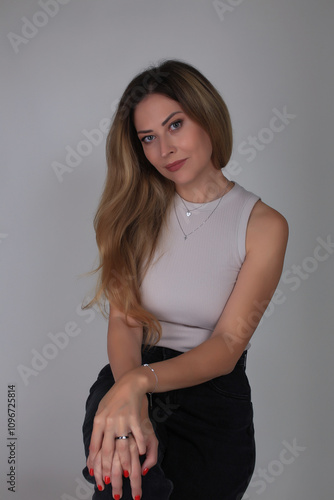 Portrait of a beautiful fashion girl blond in the studio in a nice black trousers