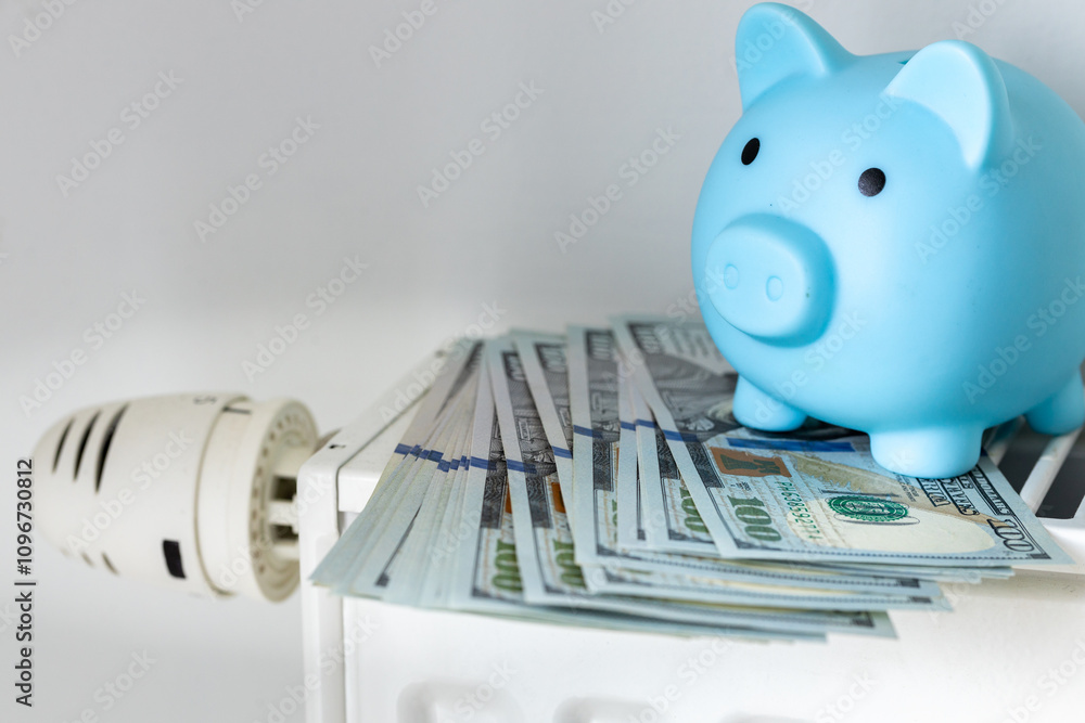 winter home heating costs. US dollars and a piggy bank on a warming radiator