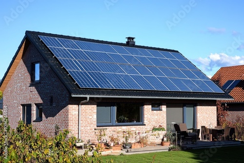 A residential house with solar panels installed on the rooftop, a sustainable energy solution photo