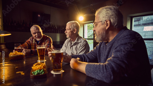 Friends, three senior men sitting in bar, drinking beer and discussing soccer game translation. Sport fans cheering favorite team. Concept of sport fans, elderly lifestyle, leisure activity, emotions