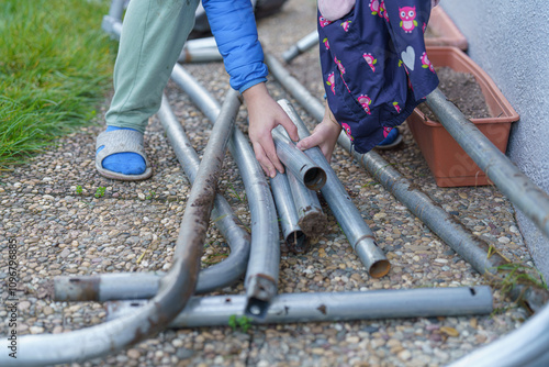 Children carry the disassembled trampoline frame for storage.