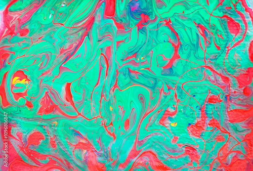Abstract background made of acrylic latex paint. Green and red spots of flowing paint. Fluid art.