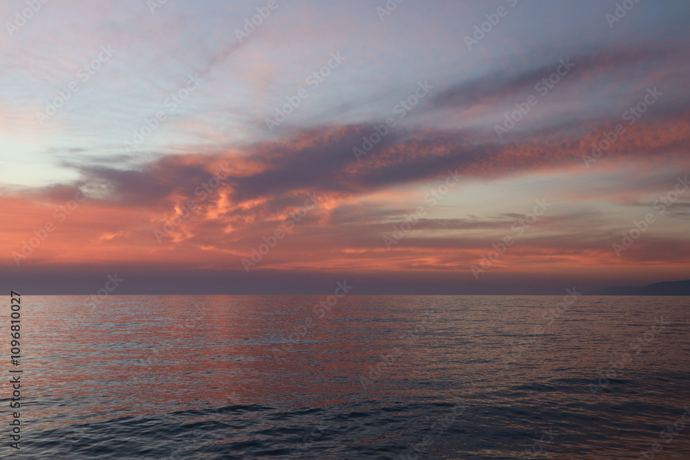 Fototapeta premium Red clouds at sunset over the sea