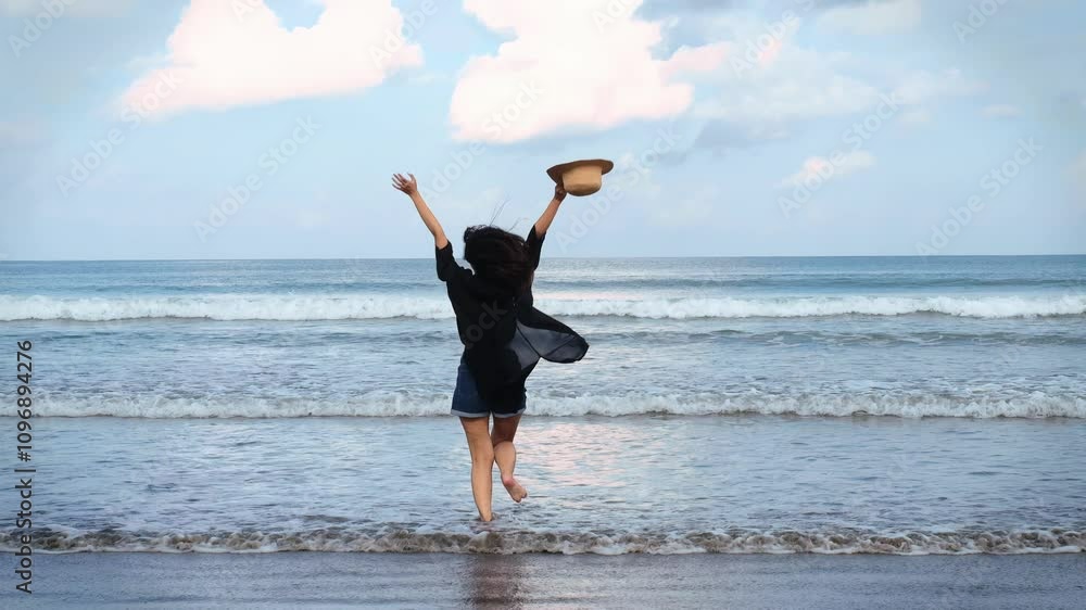 Joyful woman running on a beach while carrying a rattan hat Joyful woman running on a beach while carrying a rattan hat