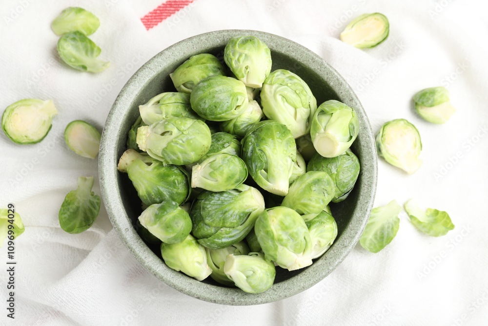Fresh Brussels sprouts in bowl on white table, top view Fresh Brussels sprouts in bowl on white table, top view