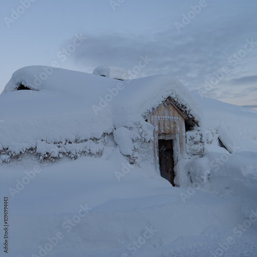 Christmas time with a house in the mountains covered with a thick layer of snow