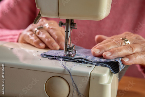 A hobbyist using an electric  sewing machine