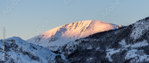 the sun shines on the mountain peaks
