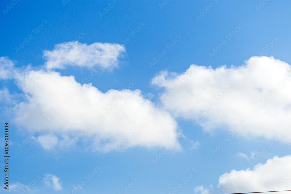 Bright blue sky with fluffy white clouds showcasing a clear day and serene atmosphere Bright blue sky with fluffy white clouds showcasing a clear day and serene atmosphere